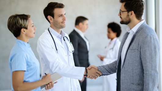Businessman,Greeting,Healthcare,Workers,And,Handshaking,With,A,Doctor,In