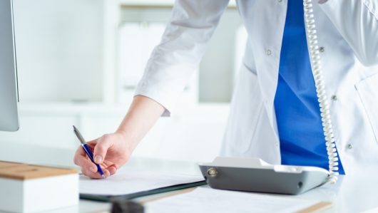Young,Practitioner,Doctor,Working,At,The,Clinic,Reception,Desk,,She